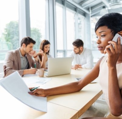 serious-businesswoman-with-documents-talking-on-P9Q6LX6@2x